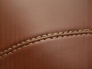 Primer plano de una costura impecable en una bolsa de piel artesanal.