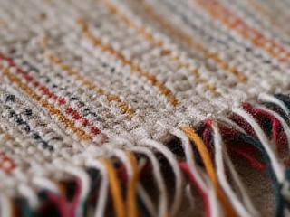 Detalle del borde de un rebozo tejido a mano, mostrando la uniformidad del hilo.